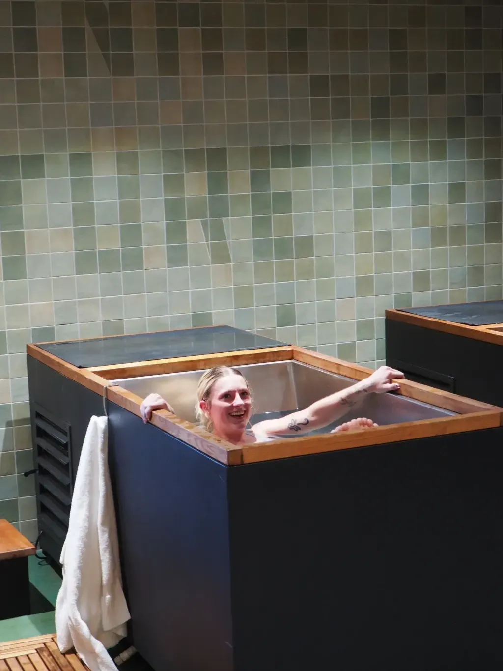 Guest smiling through a cold plunge round at Sauna Culture in Cotswold, Charlotte
