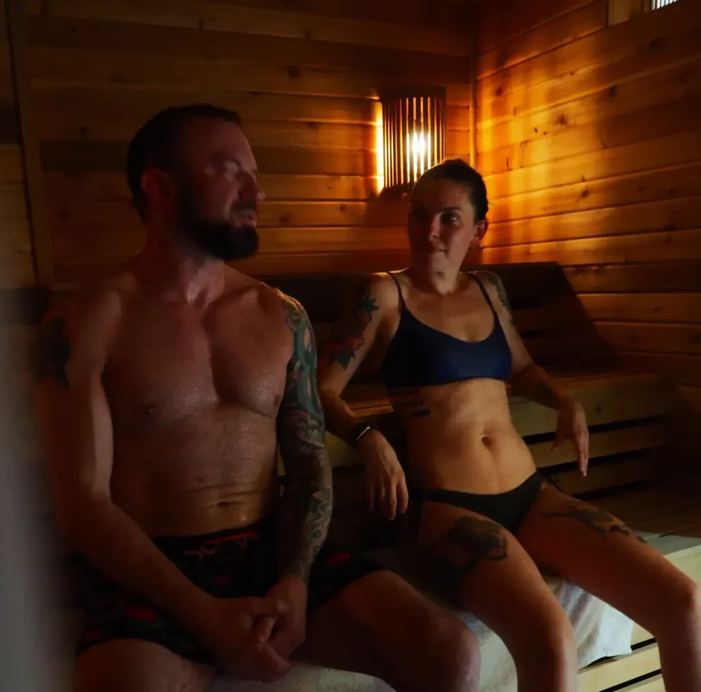 Couple relaxing side by side in the warm private Finnish sauna suite at Sauna Culture in Cotswold, Charlotte