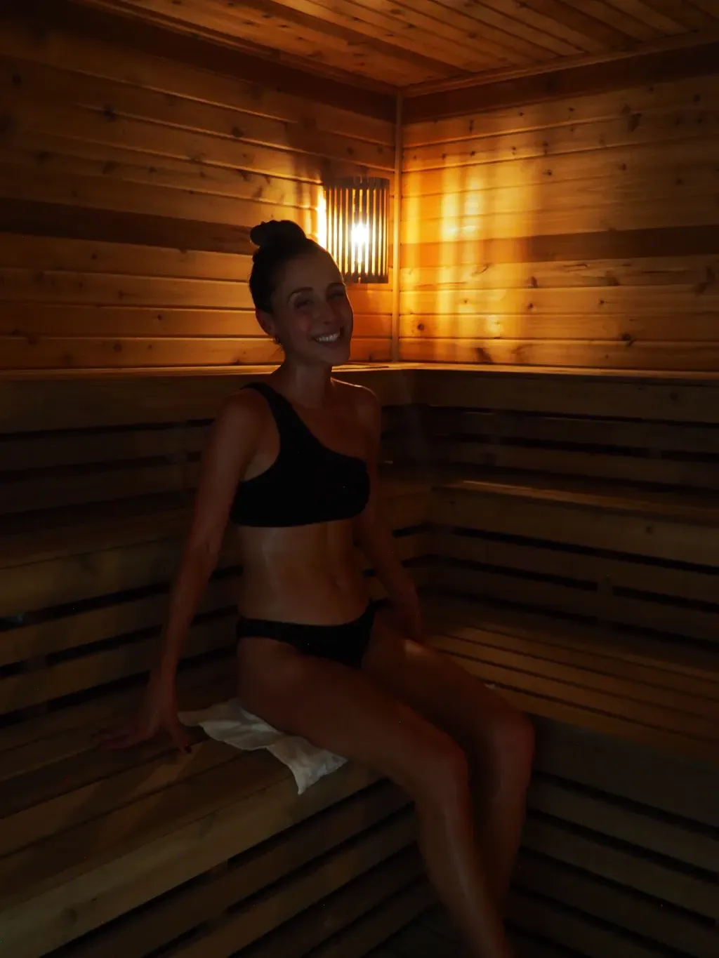 Guest smiling on the Finnish sauna bench at Sauna Culture in Cotswold, Charlotte